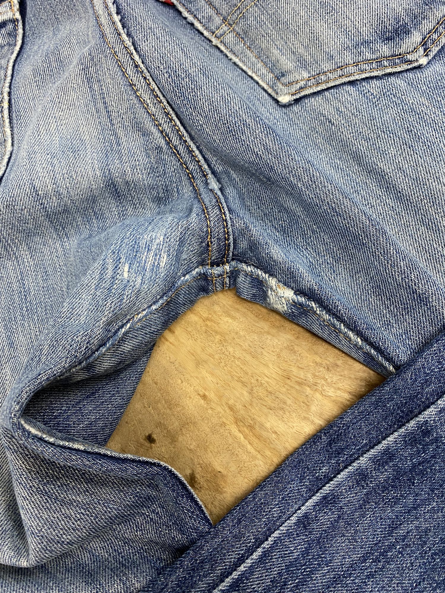 股の合わせ部分が裂けて穴が開いたデニム